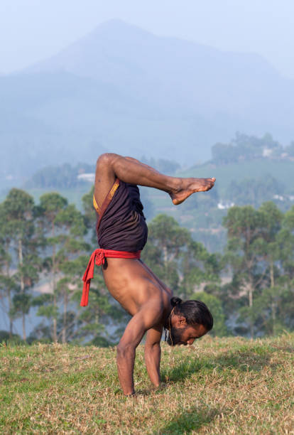 istock Indian man doing handstand outdoors in Kerala, South India 1057660296