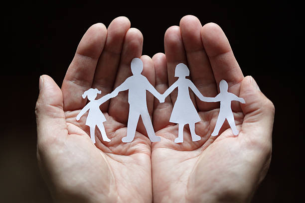istock Paper chain family protected in cupped hands 105766163