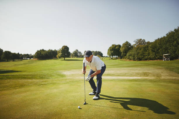 istock Senior man preparing to putt on a golf green 1057662600