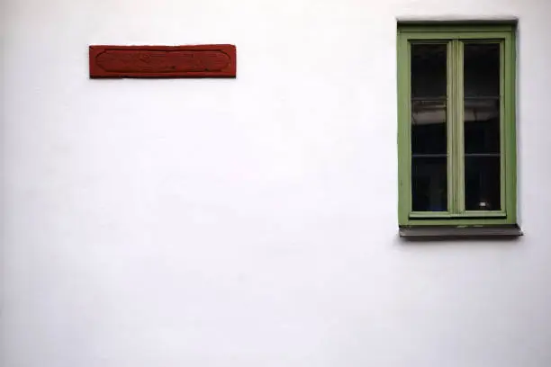 A nostalgic window with a green frame and a wooden sign."n"n"n