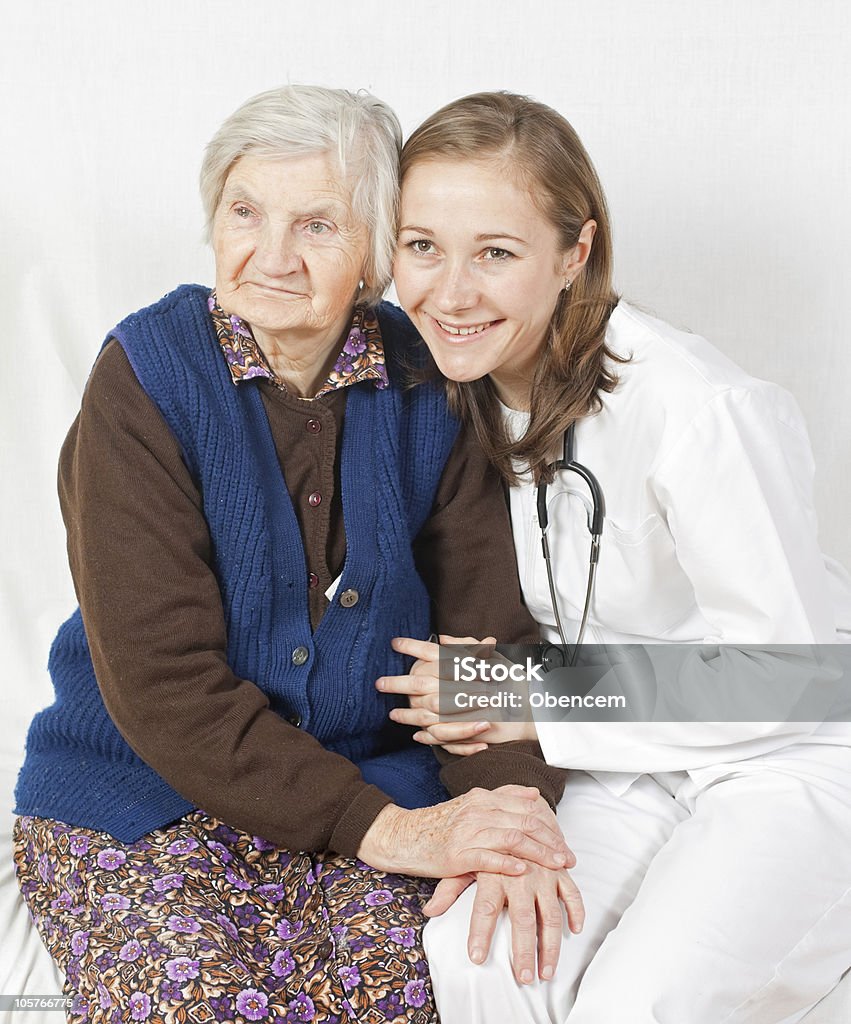 Vecchia donna e il dolce giovane medico restare insieme - Foto stock royalty-free di Accudire