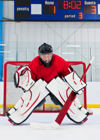Ice hockey goalie in front of his net. Picture taken on ice rink.