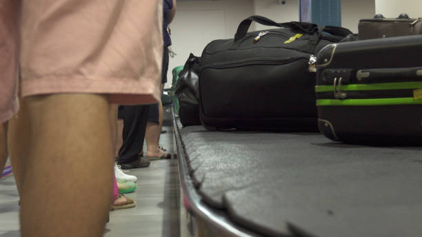istock CLOSE UP: Unknown passengers wait to collect their baggage after a long flight. 1057677176