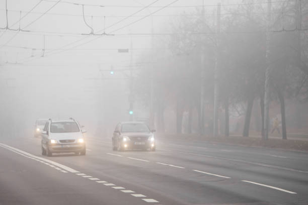 Heavy morning fog in city street. Road traffic stock photo