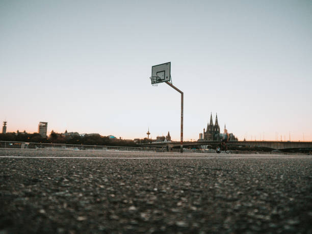 городской баскетбол обруч на закате с горизонтом кельна, германия. - court building стоковые фото и изображения