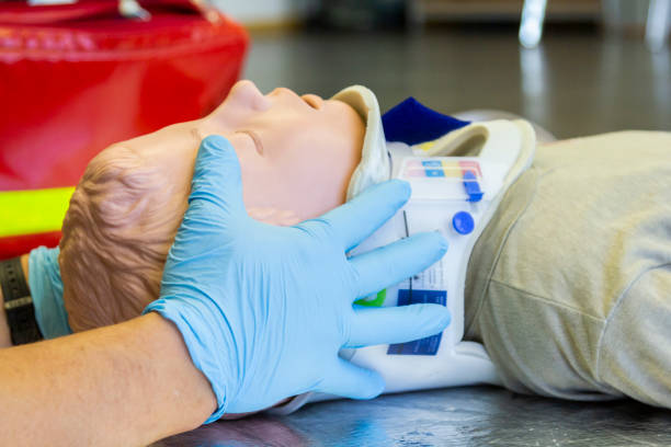 menschliche hände stabilisierung den hals von einer medizinischen ausbildung marionette für krankenwagen mann - senseless stock-fotos und bilder