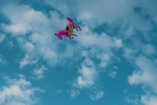 istock Lonely pink unicorn balloon flying high at the sky with a string 1057699674