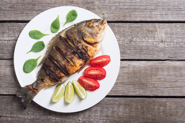 istock Fried fish dorado with lime , tomatoes and spinach 1057702664