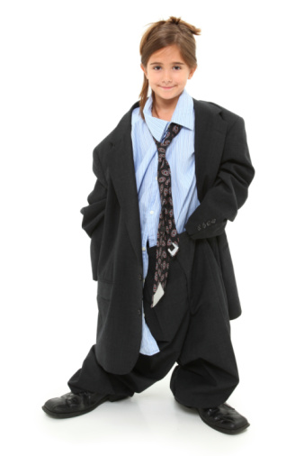 Adorable seven year old american girl in baggy over-sized suit over white background.