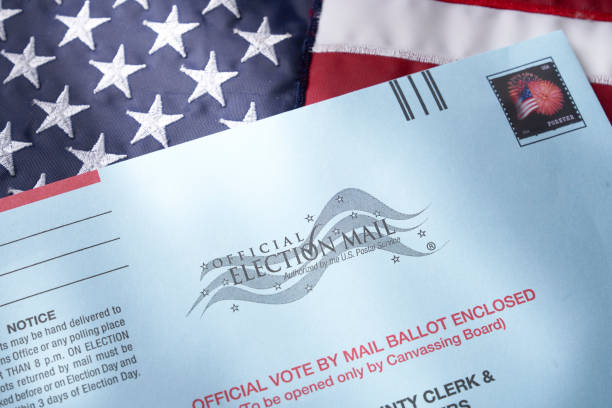 Voting ballot: Absentee voting by mail with ballot envelope on USA flag THE SEA RANCH, CALIFORNIA - October 21, 2018: Voting ballot: Absentee voting by mail with ballot envelope on USA flag. Absentee voting is voting-by-mail and allows voters who cannot visit the polls on Election Day, to cast their ballot by the US mail. absentee ballot photos stock pictures, royalty-free photos & images
