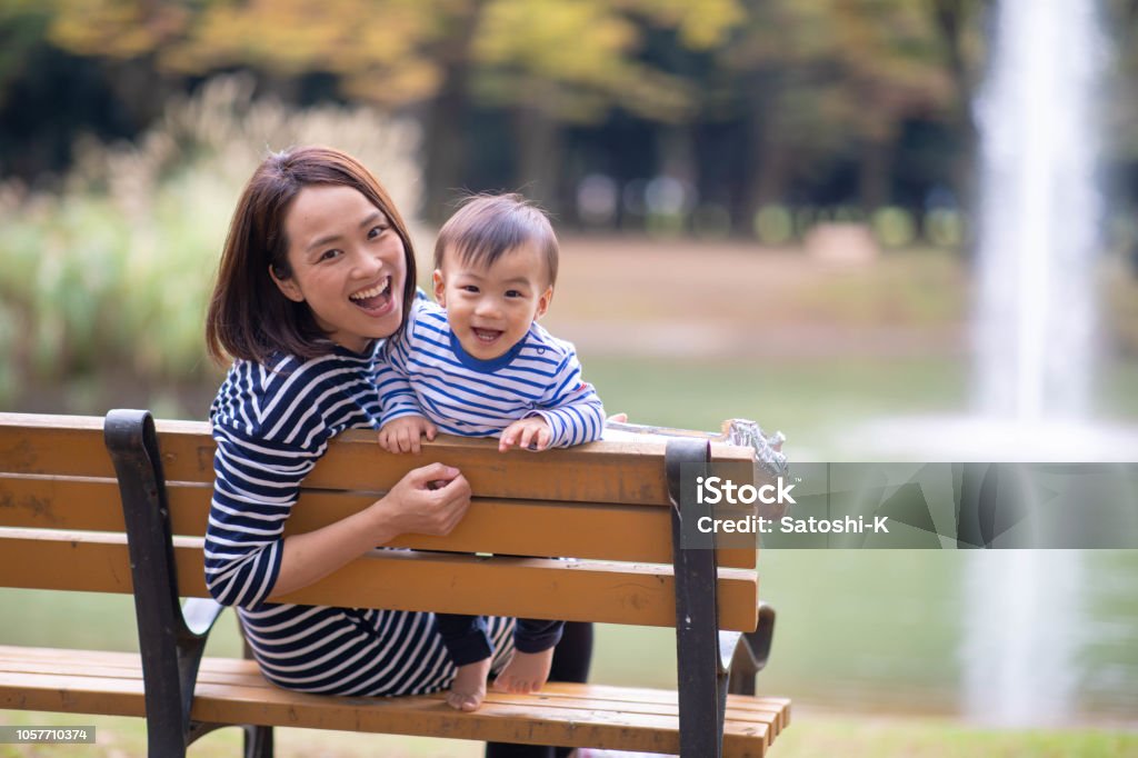 Young mother and son looking at camera in public park Mother Stock Photo