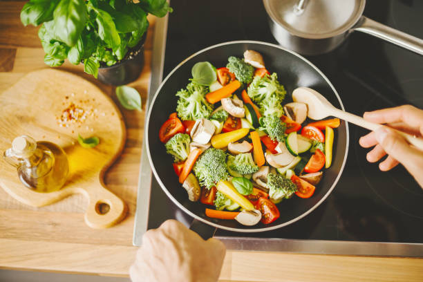 homem cozinhar legumes frescos - carrot close up silverware cutting board - fotografias e filmes do acervo