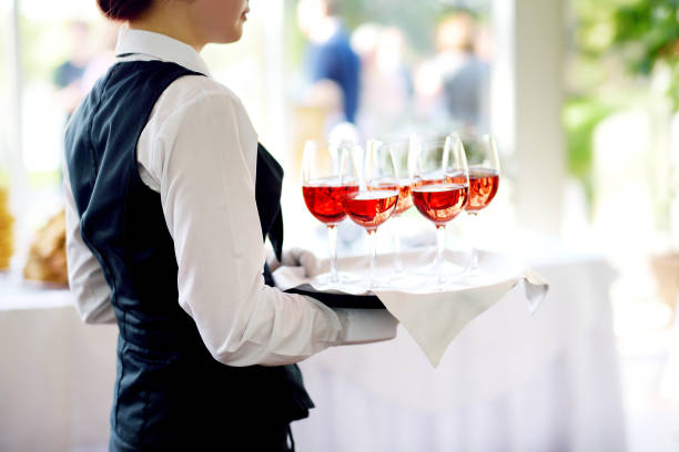 waitress holding a dish of champagne and wine glasses at festive event - wedding champagne table wedding reception imagens e fotografias de stock