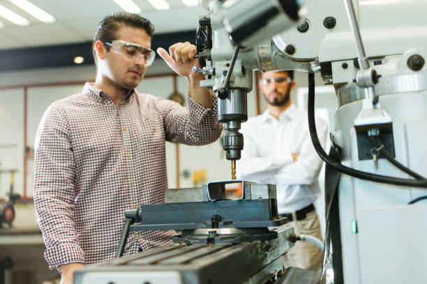 istock Latin engineers working the drill in shop 1057719114