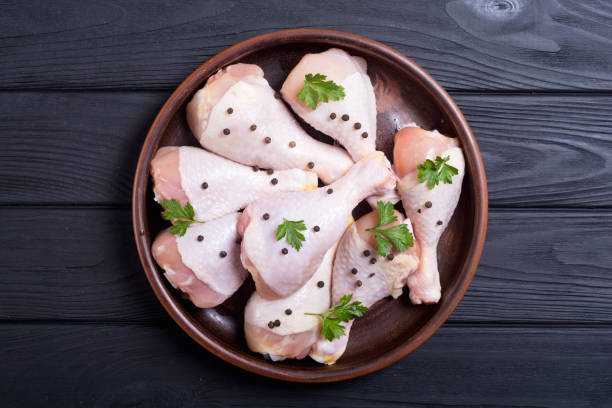 istock Raw chicken legs with spices and parsley 1057724492