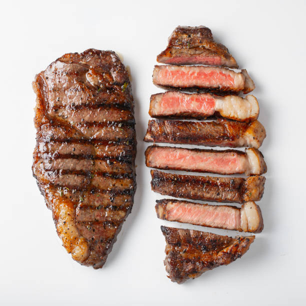 istock Two grilled marbled beef steaks striploin isolated on white background, top view 1057728756