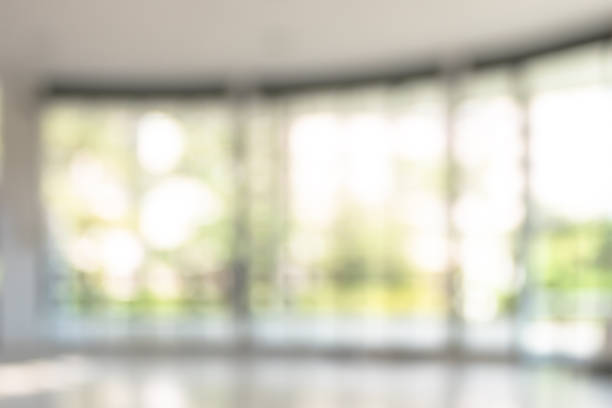 istock Blur background interior view looking out toward to empty office lobby and entrance doors and glass curtain wall 1057734356