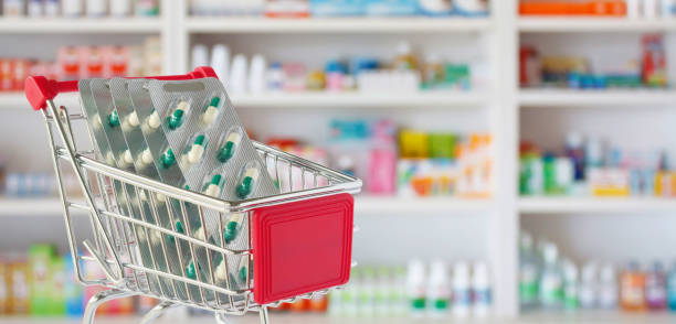 Medical pills capsule in shopping cart with pharmacy drugstore shelves blurred background Medical pills capsule in shopping cart with pharmacy drugstore shelves blurred background over the counter meds stock pictures, royalty-free photos & images