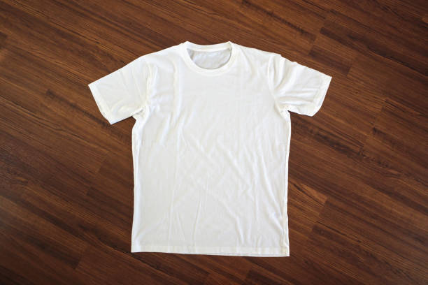 istock White t-shirt on wood background 1057734630
