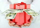 A red gift box with hundred dollar bills