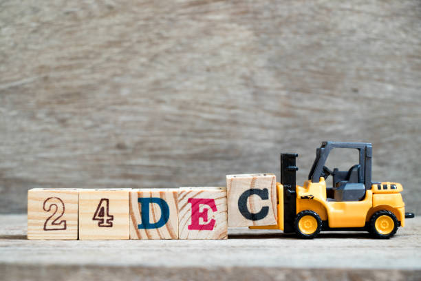 istock Toy forklift hold block c to complete word 24dec on wood background (Concept for calendar date 24 in month December) 1057758232