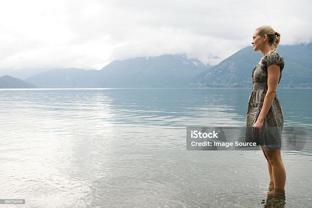 Jovem mulher em pé em lake - Foto de stock de Lago royalty-free
