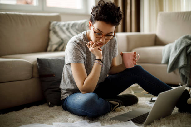 junge frau, die zu hause arbeitet - floor sitting stock-fotos und bilder