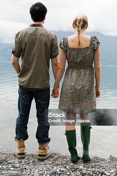 Young Couple Standing By Lake Holding Hands 다민족 그룹에 대한 스톡 사진 및 기타 이미지 - 다민족 그룹, 서 있기, 혼혈인