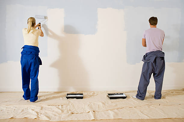 jovem casal pintando uma parede - pintar parede imagens e fotografias de stock