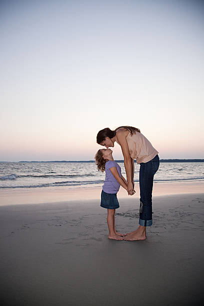 cariñoso madre e hija en la playa - face to face twilight togetherness vertical fotografías e imágenes de stock