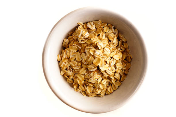 istock Raw Oatmeal in  Bowl Isolated on White 1057770882