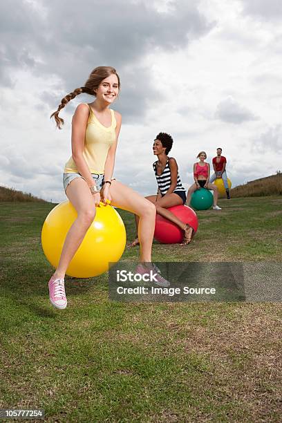 Young People Bouncing On Hoppity Horses Stock Photo - Download Image Now - Hoppity Horse, 20-24 Years, Activity