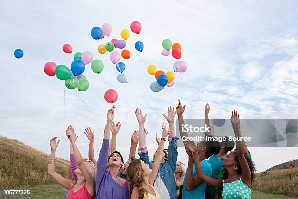 Young People Releasing Balloons Stock Photo - Download Image Now - Balloon, Releasing, People