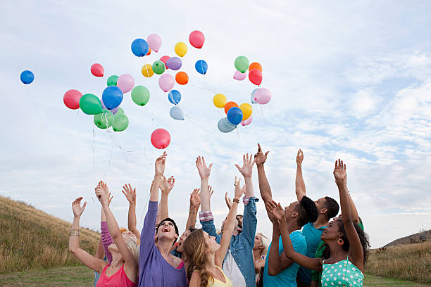 młodzi ludzie uwalniać balony - releasing zdjęcia i obrazy z banku zdjęć
