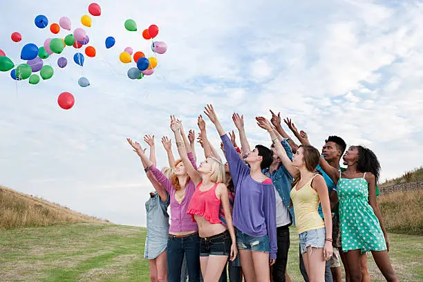 Photo of Young people releasing balloons