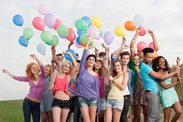 Photo of Young people holding balloons