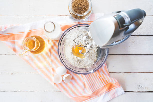 mezcla de harina y huevos con una batidora de mesa - mixing bowl fotografías e imágenes de stock