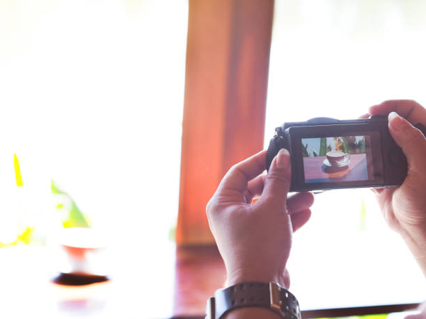 istock hand taking picture from mirror less camera at coffee shop 1057776444