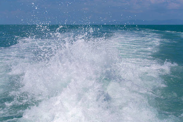 vague d’eau de mer océan bleu avec bateau yacht rapide wake mousse de lavage prop. gros plan - prop wash photos et images de collection