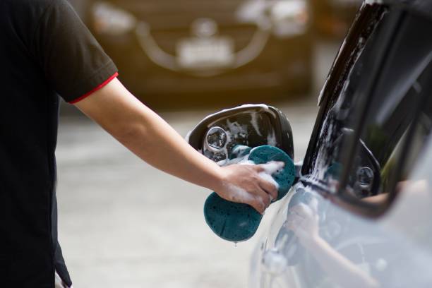 istock Male hands hold with blue sponge washing car. 1057784296