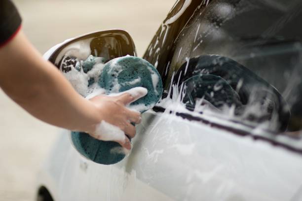 istock Male hands hold with blue sponge washing car. 1057784346