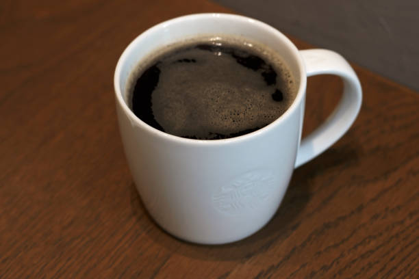 istock Black coffee mug on the table close-up 1057784474