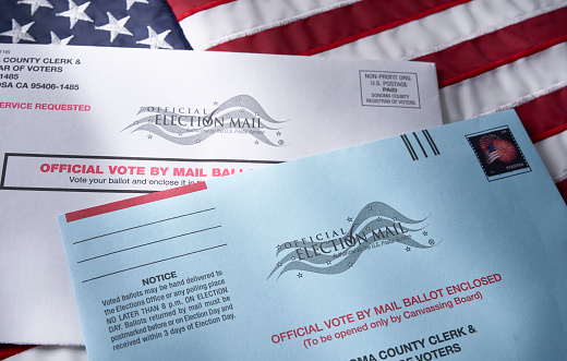 THE SEA RANCH, CALIFORNIA - October 21, 2018: Voting ballot: Absentee voting by mail with ballot envelope on USA flag. Absentee voting is voting-by-mail and allows voters who cannot visit the polls on Election Day, to cast their ballot by the US mail.