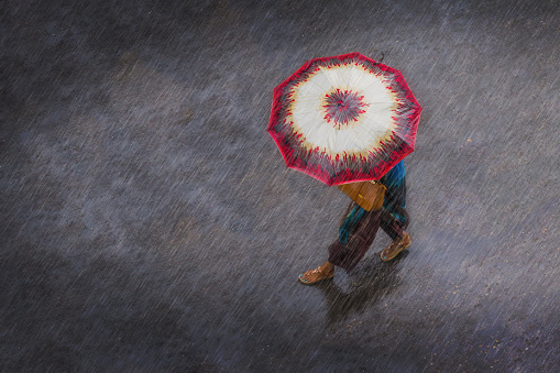 woman walking in the rain with colourful umbrella