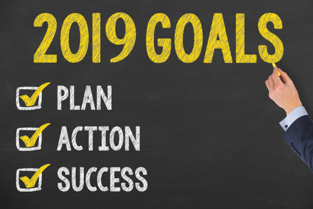 istock Human Hand Writing New Year 2019 Goals on Chalkboard 1057792354