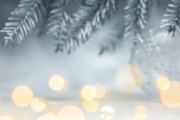 istock christmas silver background with blurred fir tree branches and defocused garland lights 1057794610