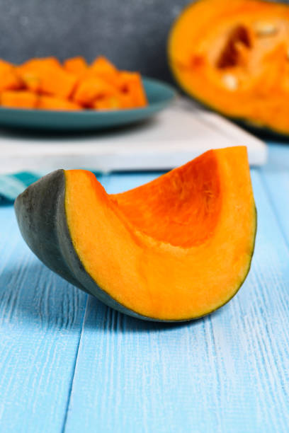 istock Sliced pumpkin into pieces for cooking pumpkin soup or mashed potatoes. Pumpkin on a blue wooden table. 1057797190