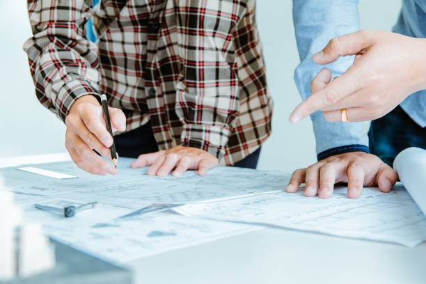istock Concept architects, Engineer holding pen pointing equipment architects On the desk with a blueprint in the office.Selective Focus 1057802060