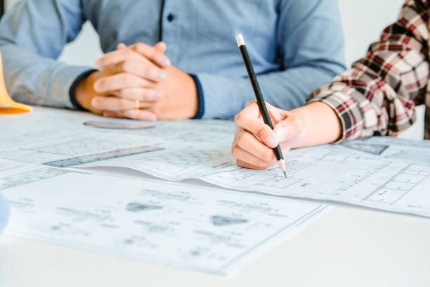 istock Concept architects, Engineer holding pen pointing equipment architects On the desk with a blueprint in the office.Selective Focus 1057802062
