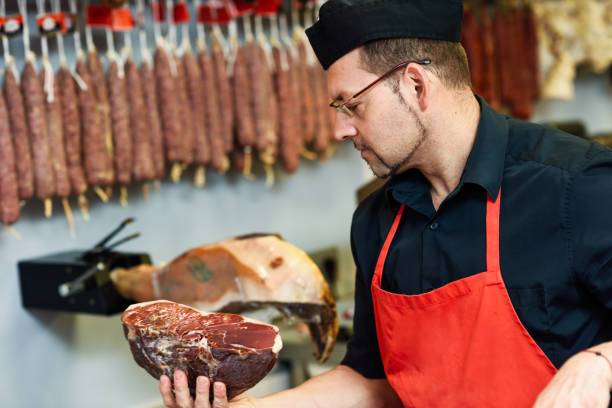 istock Butcher with a piece of ham in his hand 1057802210